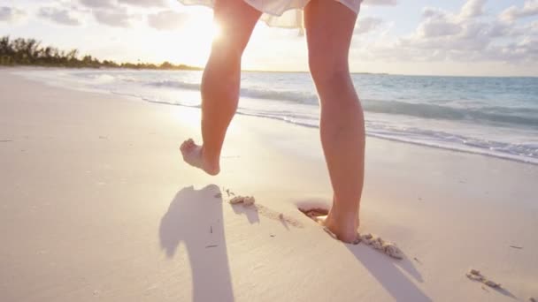 Gambe di donna che cammina a piedi nudi su una spiaggia — Video Stock