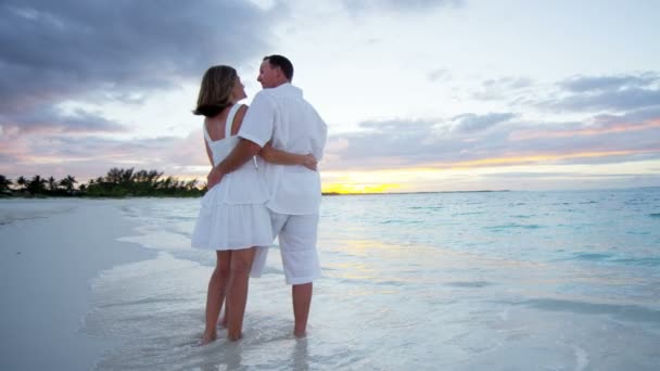 Casal caucasiano na praia tropical ao pôr do sol — Vídeo de Stock