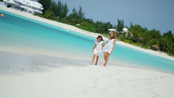 Meisjes in witte kleren wandelen op het strand — Stockvideo