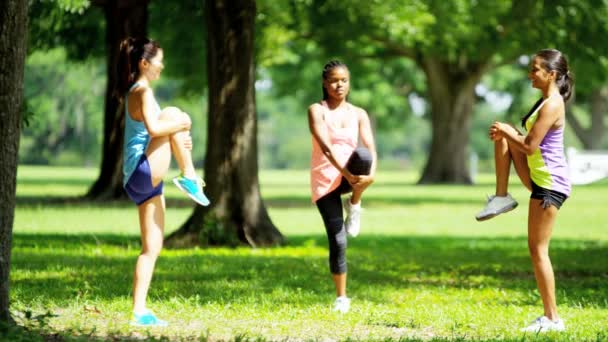 Multi etniska flickor njuter av stretching i park — Stockvideo