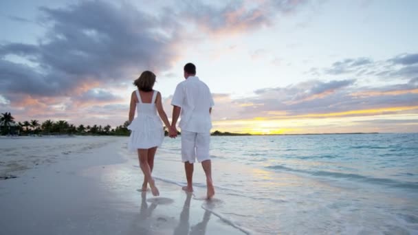 Caucásico pareja en tropical playa al atardecer — Vídeos de Stock