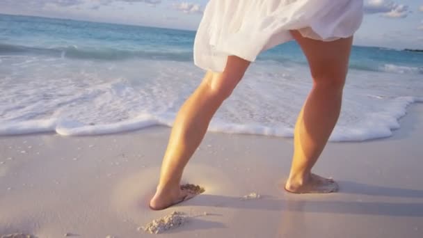 Kobieta boso, chodzenie po plaży o zachodzie słońca — Wideo stockowe
