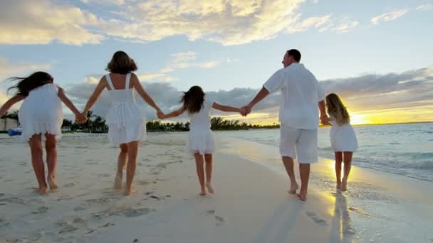Familia caucásica disfrutando de vacaciones en la playa al atardecer — Vídeo de stock