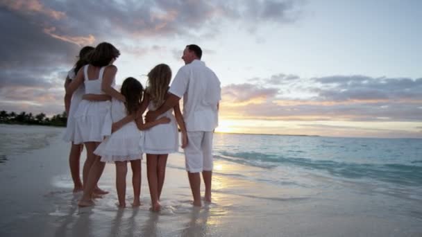 Família caucasiana desfrutando de férias na praia ao pôr do sol — Vídeo de Stock