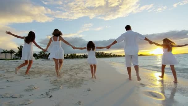 Família caucasiana desfrutando de férias na praia ao pôr do sol — Vídeo de Stock