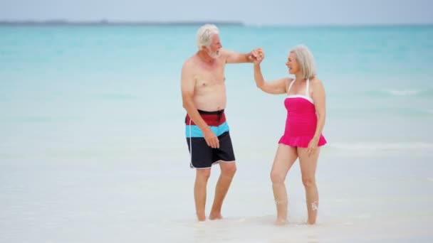 Pareja de ancianos disfrutando de vacaciones en la playa — Vídeo de stock