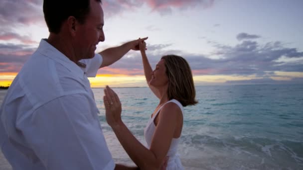 Caucásico pareja en tropical playa al atardecer — Vídeos de Stock