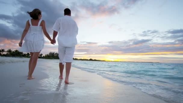 Caucásico pareja en tropical playa al atardecer — Vídeos de Stock