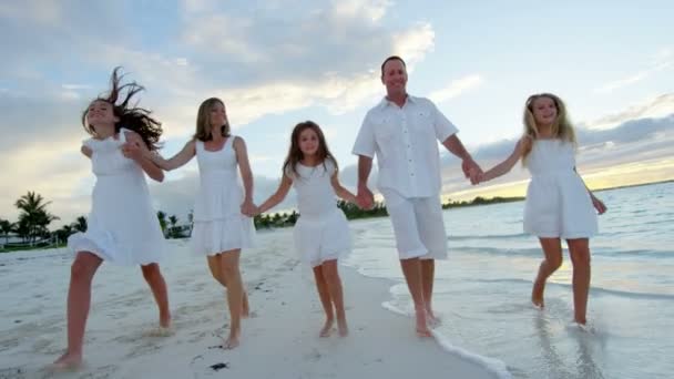 Familia caucásica disfrutando de vacaciones en la playa al atardecer — Vídeo de stock