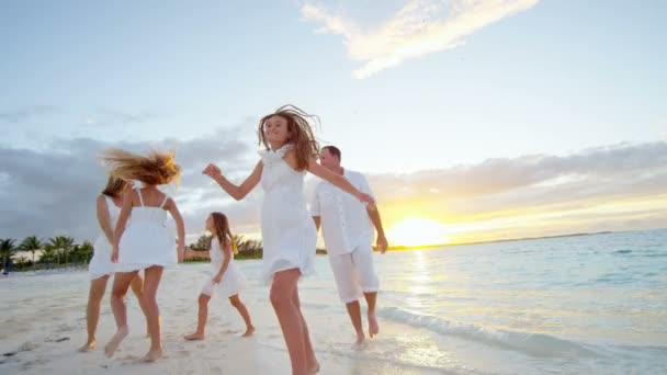 Familia caucásica disfrutando de vacaciones en la playa al atardecer — Vídeos de Stock