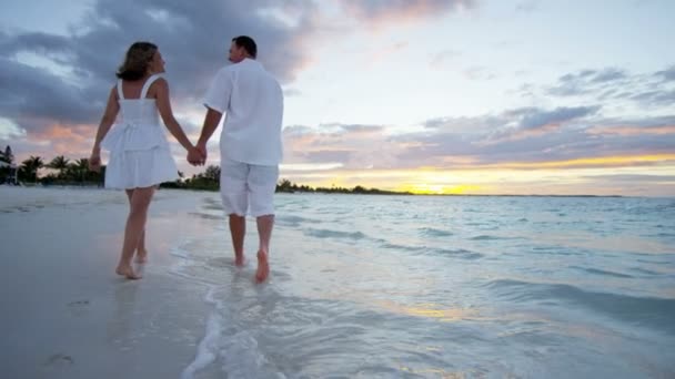 Casal caucasiano na praia tropical ao pôr do sol — Vídeo de Stock