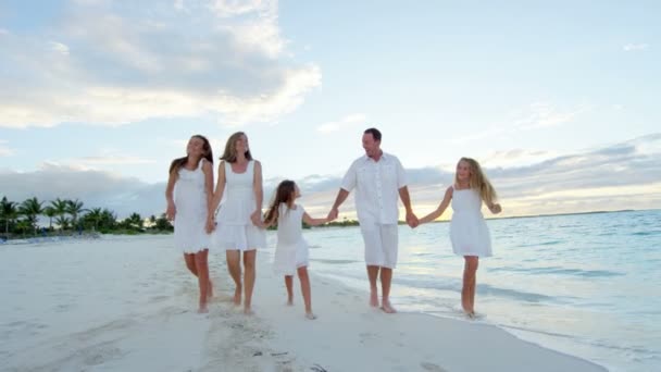 Familia caucásica disfrutando de vacaciones en la playa al atardecer — Vídeo de stock