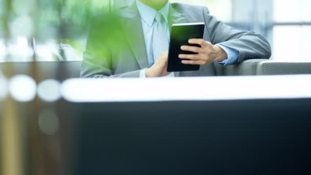 Asiático hombre de negocios en edificio de oficinas usando tableta — Vídeo de stock