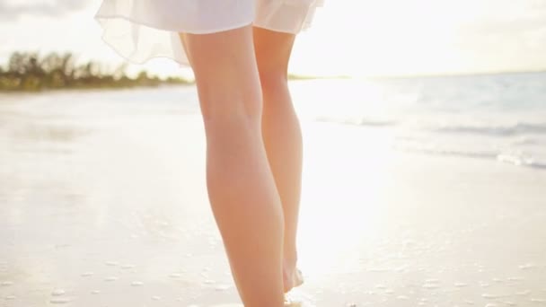 Kvinnan barfota promenader på stranden vid solnedgången — Stockvideo