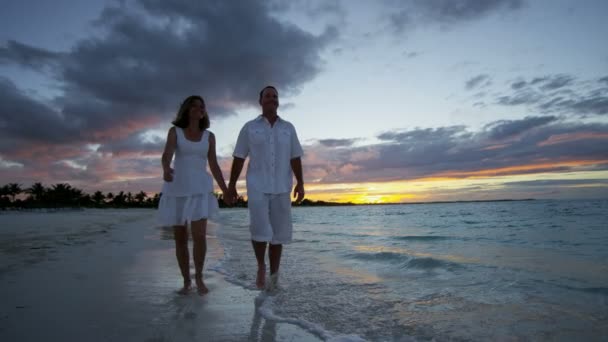 Casal caucasiano na praia tropical ao pôr do sol — Vídeo de Stock
