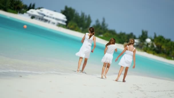 Flickor i vita kläder promenerar på stranden — Stockvideo