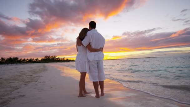 Kaukasisk par på tropiska stranden i solnedgången — Stockvideo