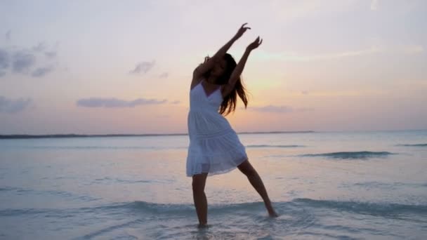 Chinees meisje in witte jurk dansen op strand — Stockvideo