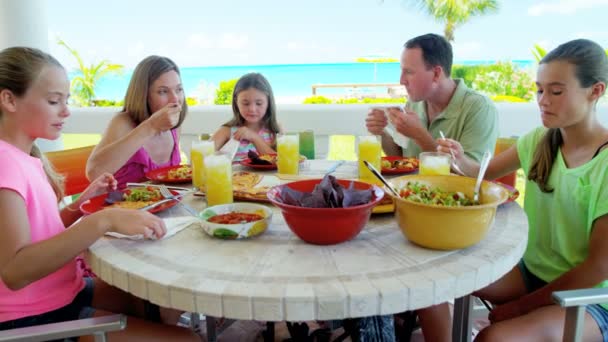 Família caucasiana desfrutando de comer na praia — Vídeo de Stock