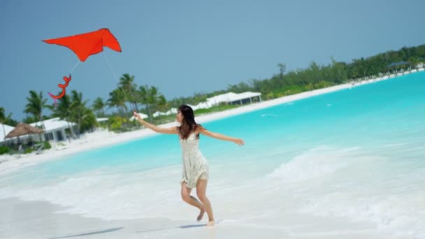 Chica asiática jugando con cometa roja en la playa — Vídeo de stock