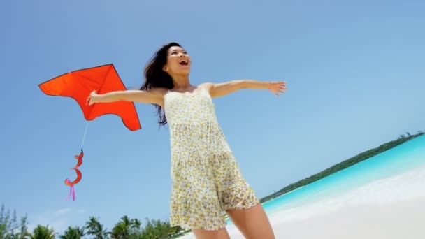 Chica asiática jugando con cometa roja en la playa — Vídeo de stock