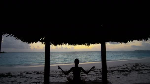 Jong meisje beoefenen van yoga op het strand — Stockvideo