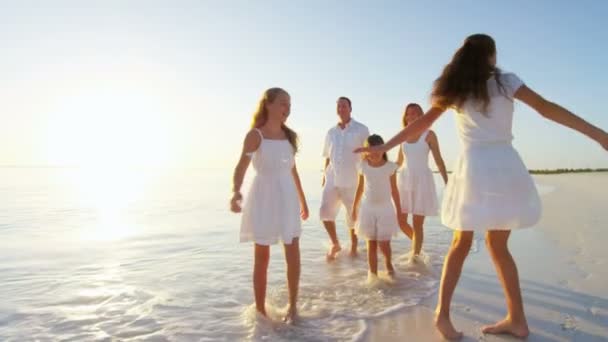 Familia caucásica disfrutando de vacaciones en la playa al atardecer — Vídeos de Stock