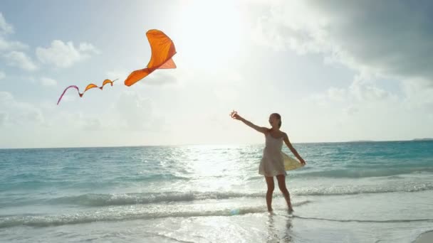 Asian girl playing with red kite on beach — Stock Video