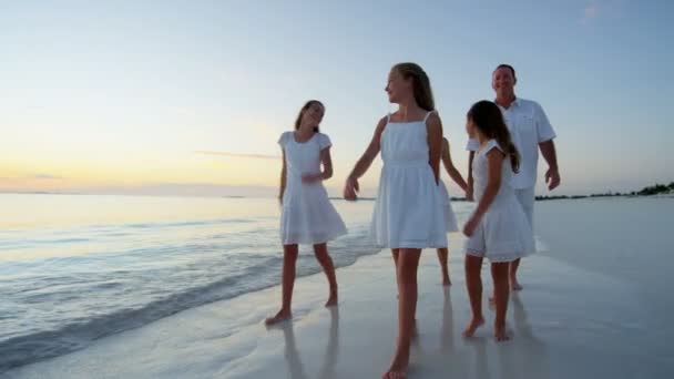 Familia caucásica disfrutando de vacaciones en la playa al atardecer — Vídeos de Stock