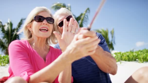 Pareja mayor tomando selfie en la playa — Vídeos de Stock