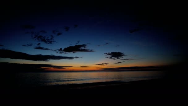 Onde oceaniche lavaggio spiaggia sabbiosa al tramonto — Video Stock