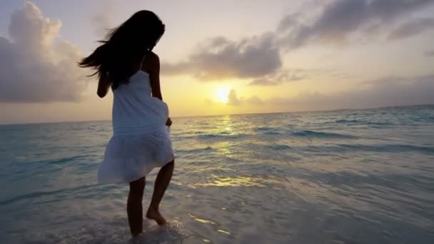 Aziatische Chinees meisje bij zonsondergang op het strand — Stockvideo