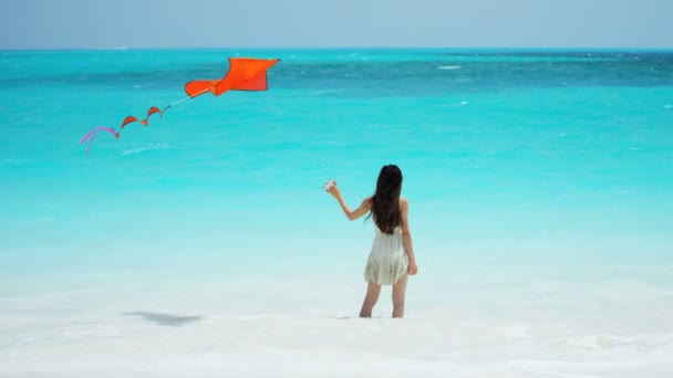 Ragazza asiatica che gioca con aquilone rosso sulla spiaggia — Video Stock