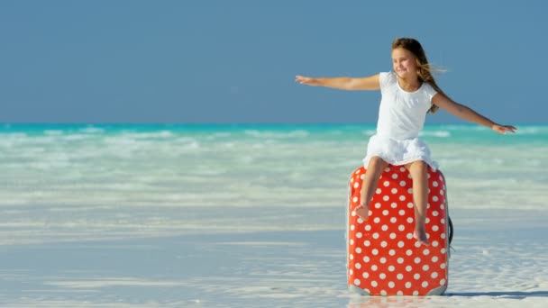 Bambina su una spiaggia seduta su una valigia — Video Stock