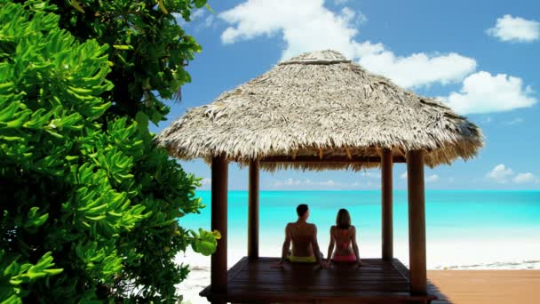 Pareja en thatched tiki cabaña en playa — Vídeos de Stock