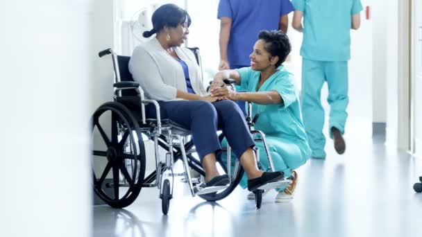 Kadın hemşire ve hasta hastanede tekerlekli sandalye üzerinde — Stok video