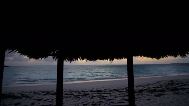 Cabaña tiki de playa al atardecer — Vídeo de stock