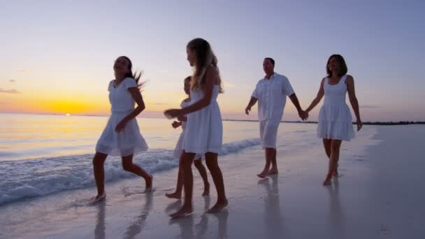 Família caucasiana desfrutando de férias na praia ao pôr do sol — Vídeo de Stock