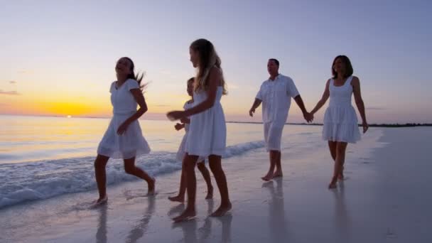 Familia caucásica disfrutando de vacaciones en la playa al atardecer — Vídeo de stock