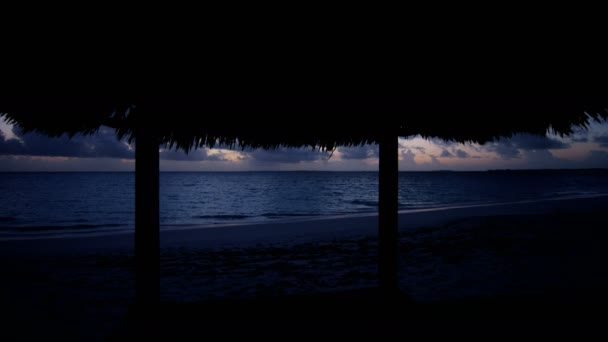 Cabaña tiki de playa al atardecer — Vídeo de stock