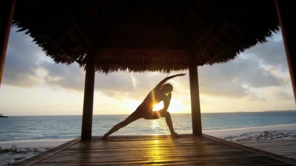 Chica joven practicando yoga en la playa — Vídeo de stock