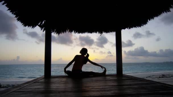 Chica joven practicando yoga en la playa — Vídeo de stock