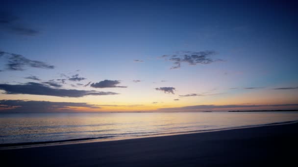 Ocean waves washing sandy beach at sunset — Stock Video