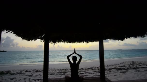 Jong meisje beoefenen van yoga op het strand — Stockvideo