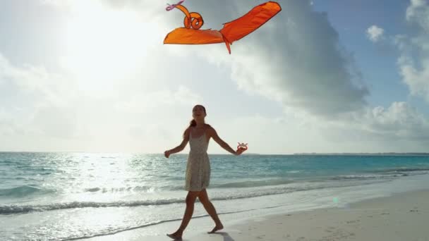 Asyalı kız ile kırmızı uçurtma sahilde oynarken — Stok video