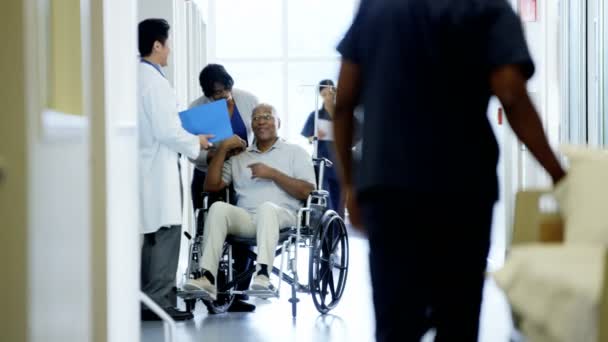 Мужчина на инвалидной коляске с женой консультируется с врачом — стоковое видео