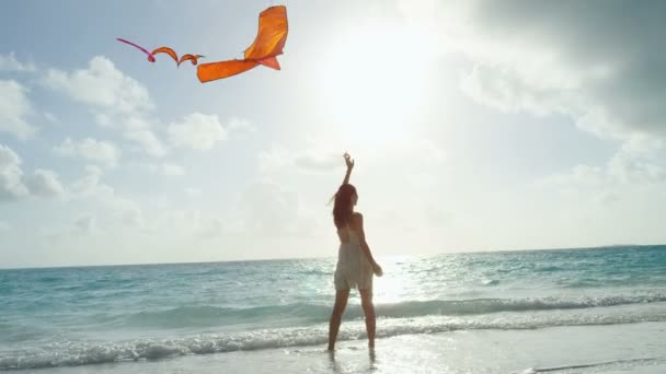 Ragazza asiatica che gioca con aquilone rosso sulla spiaggia — Video Stock