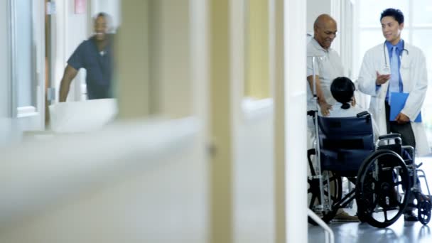 Женщина на инвалидной коляске с мужем консультируется с врачом — стоковое видео