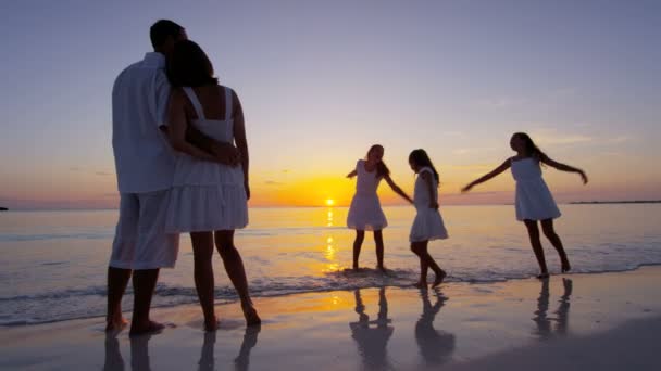 Caucasian family enjoying beach vacation at sunset — Stock Video