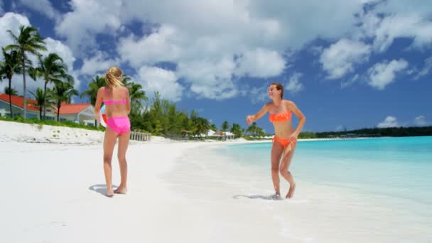Chicas jóvenes jugando con la pelota en una playa — Vídeo de stock